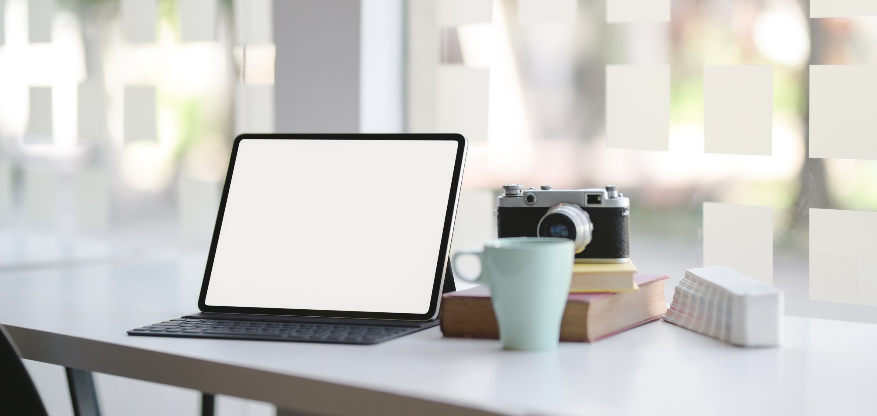 Macbook Pro Beside Blue Ceramic Mug on Brown Wooden Table